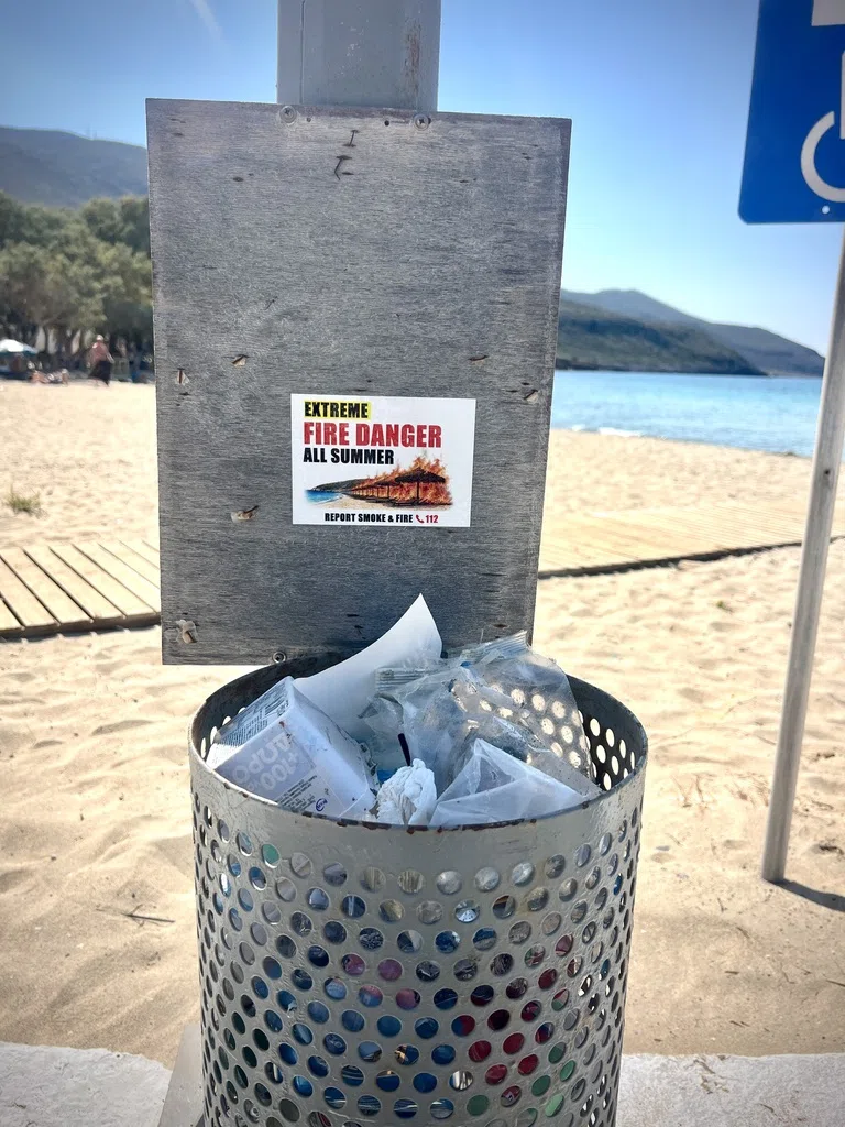 An English extreme fire danger sticker above a litter bin at the beach